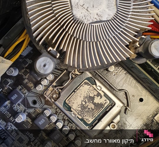 מעבד ומאוורר במחשב עם אבק על לוח האם